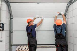 Technicians installing a residential garage door panel